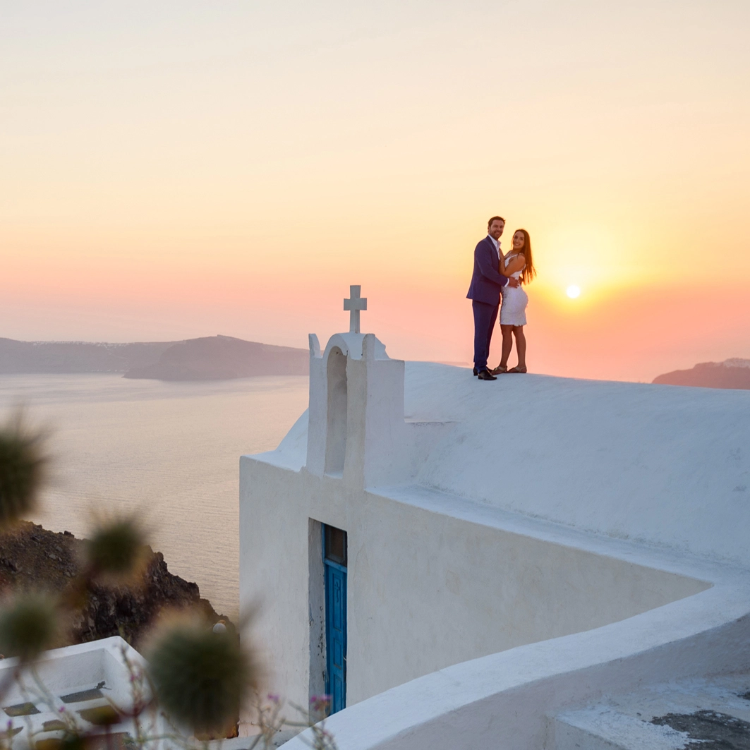 Sunset over a chapel, the bride and groom are embraced to enjoy their private moment