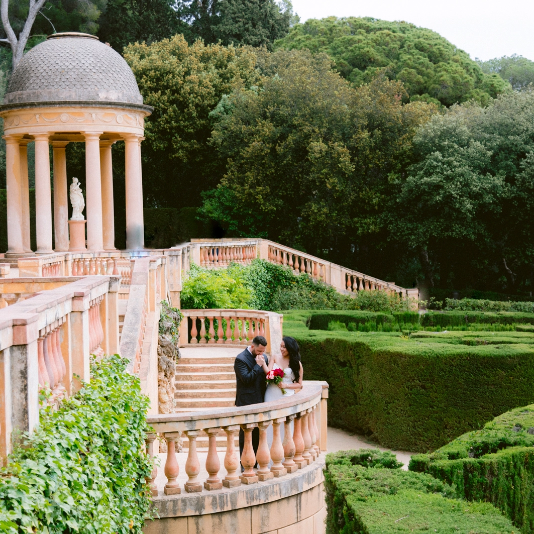 Barcelona elopement The coule during the photo tour in Barcelona, the groom kiss the bride hand, in the garden