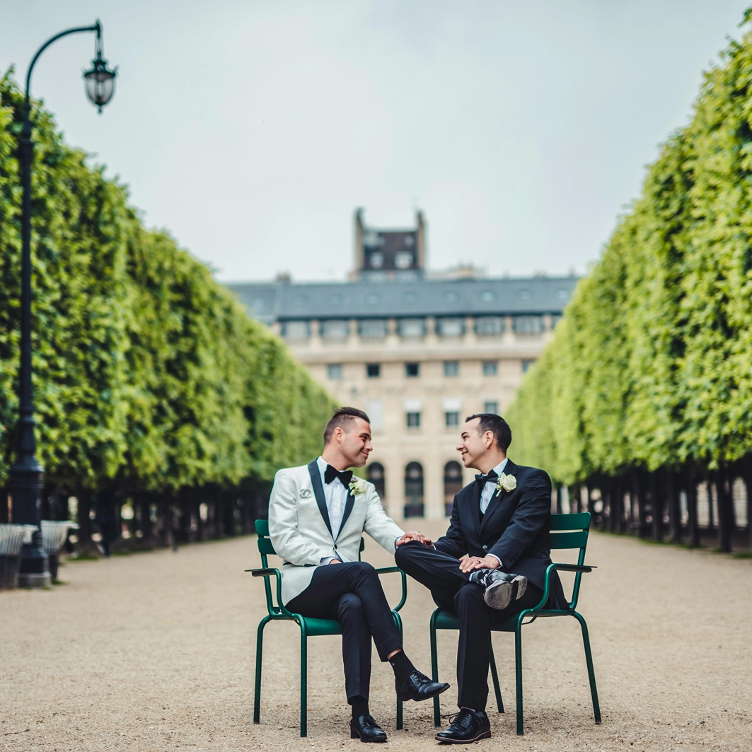 gay wedding in paris A couple of groom sit facing each other in the Tuilerie gardens, in Paris
