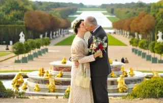 The couple is over the Chateau de versailles garden.