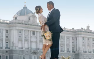 The couple stand on a wall for a creative photo