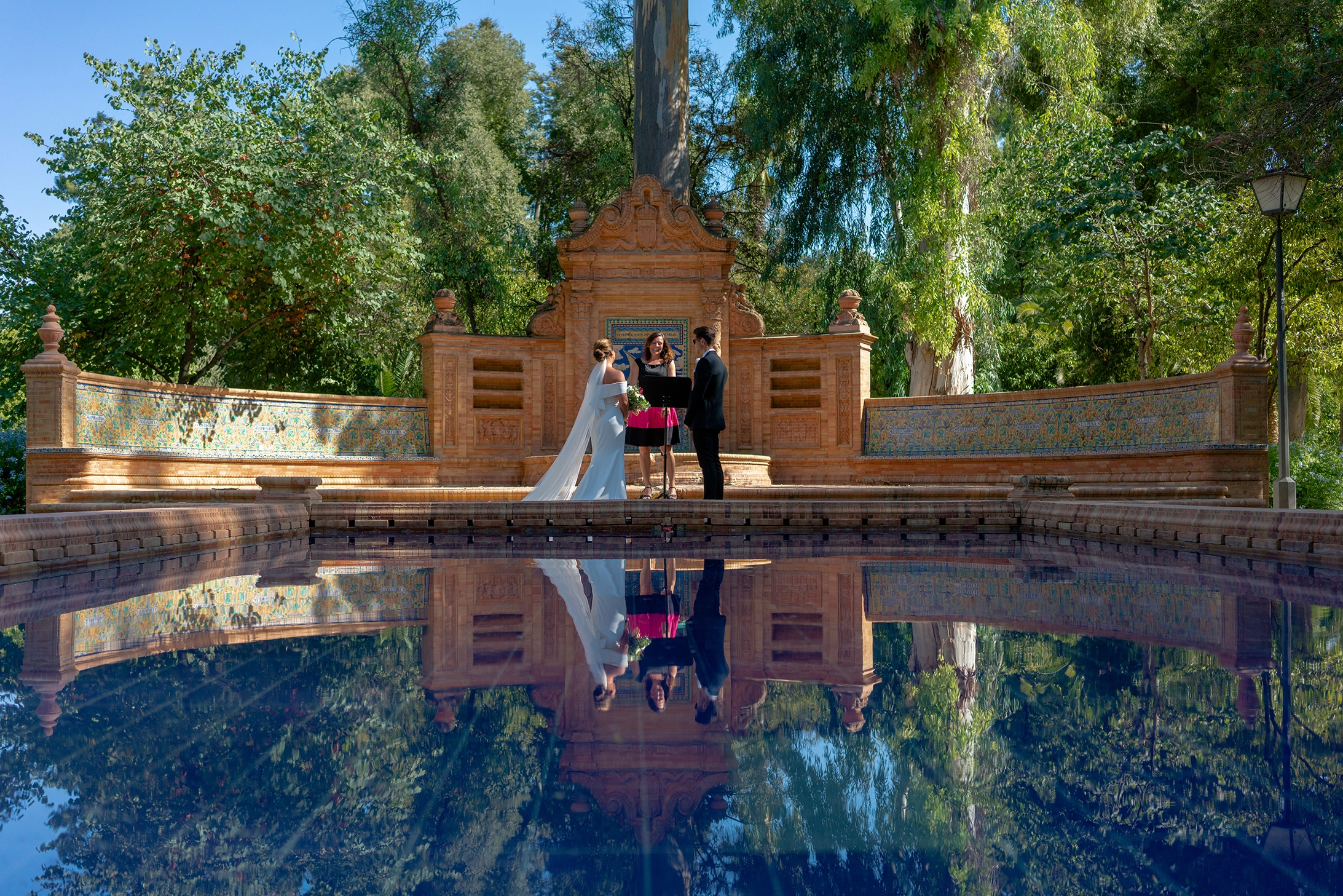 the lake and green around are a great background for the couple during the elopement in Seville