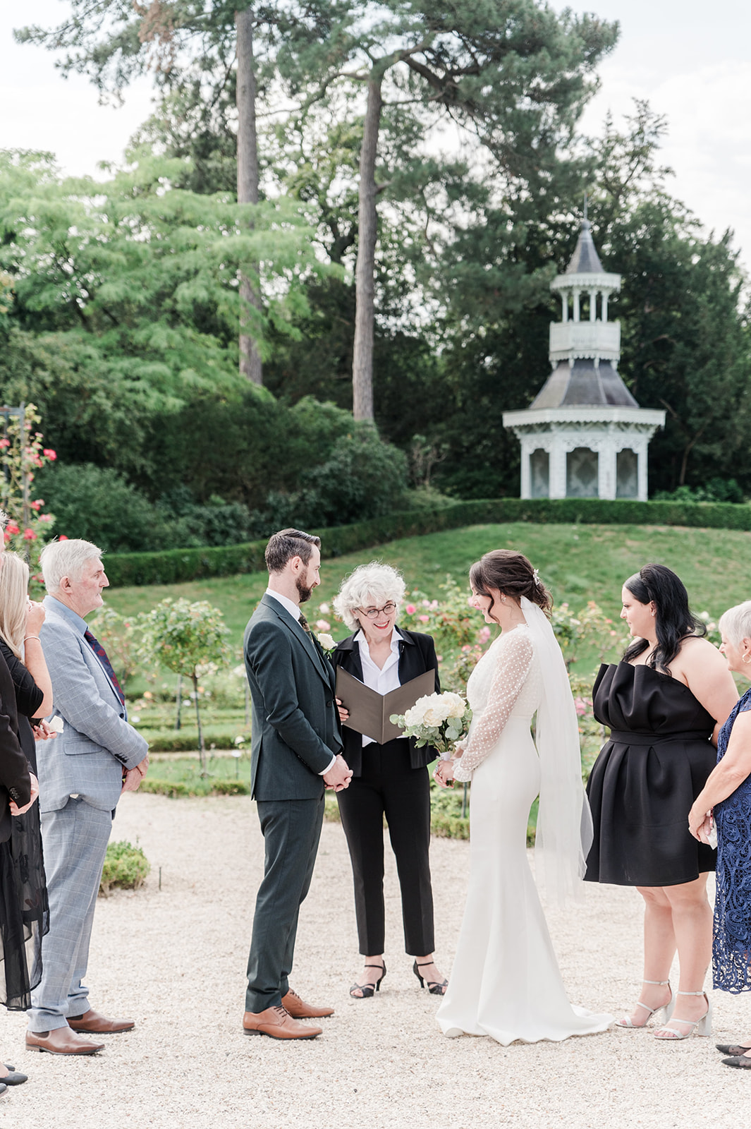beautiful green background behind bride and groom at Parc de bagatelle beautiful green background behind bride and groom