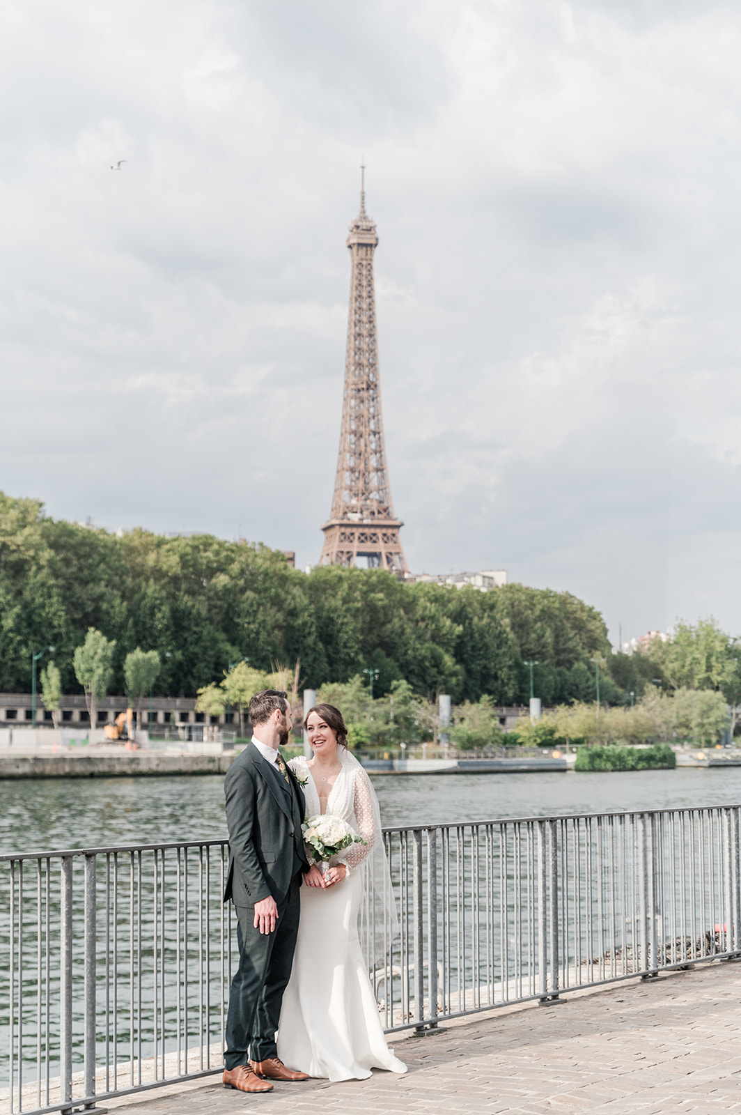 the beautiful river bank at the Eiffel tower bride and groom embracing each others at the beautiful river bank at the Eiffel tower