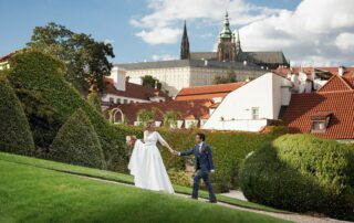 The couple walking in a garden with a old fountain in Prague