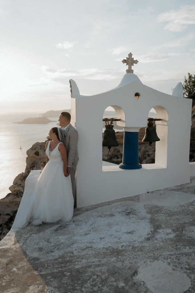 The couple posing at Sunset on a roof in Fira, Santorini