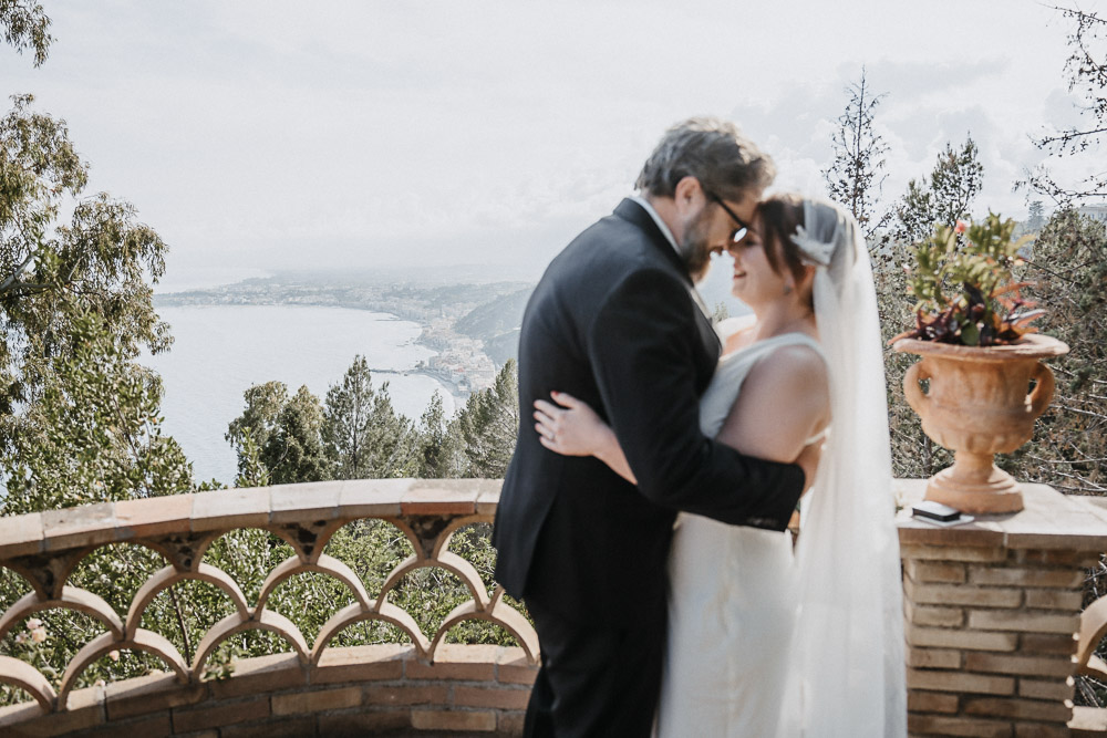The couple on a balcony in Winter for their wedding shoot in Sicily