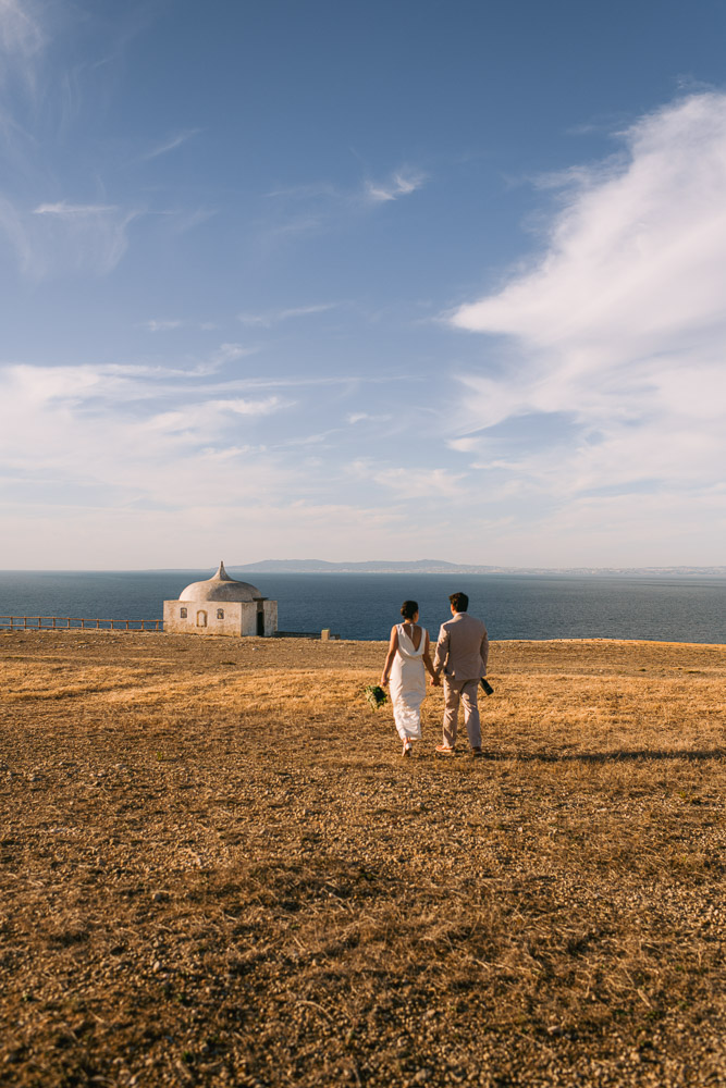 the couple walking on the cliff of Sesimbra, Portugal.