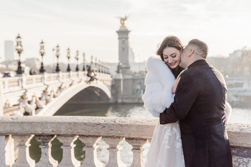 The couple with warm sun of Winter in Paris at the Alexandre III bridge