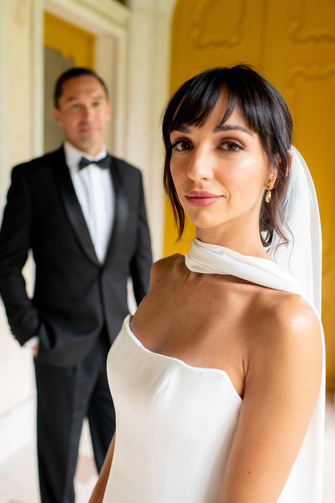 The bride posing in head shot and the groom in the background after their elopement in Sintra